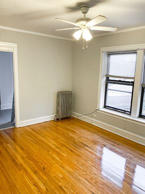 Chicago apartment for rent - an empty room with wooden floors and a ceiling fan