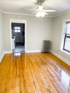 Chicago apartment for rent - an empty living room with wood floors and a ceiling fan