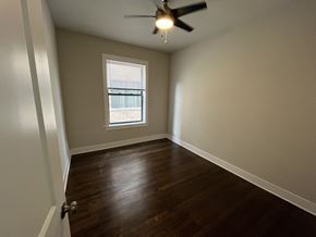 Chicago apartment for rent - A room with a ceiling fan and a window.