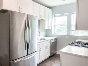 Chicago apartment for rent - A modern kitchen with a stainless steel refrigerator and white cabinets.