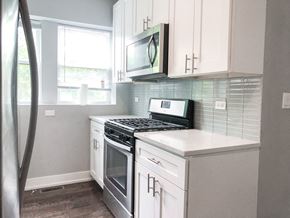 Chicago apartment for rent - A kitchen with white cabinets and a black stove top oven.