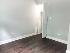 Chicago apartment for rent - A room with a white door and wooden flooring.