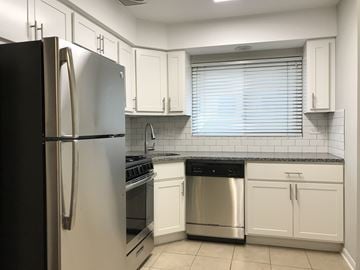 Chicago apartment for rent - A kitchen with a black refrigerator and white cabinets.