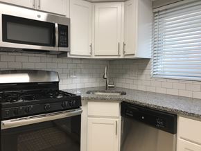 Chicago apartment for rent - A kitchen with a black stove top oven and a black dishwasher.