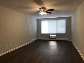 Chicago apartment for rent - A room with a ceiling fan and a window with blinds.