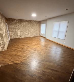Chicago apartment for rent - A room with wooden flooring and a brick wall.