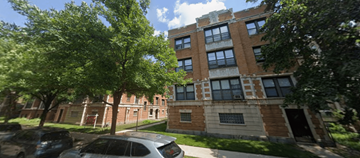 Chicago apartment for rent - A tree in front of a building with a car parked in front of it.
