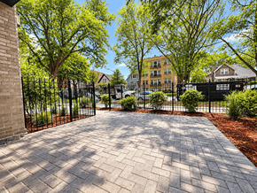 Chicago apartment for rent - A brick pathway leads to a gated entrance.