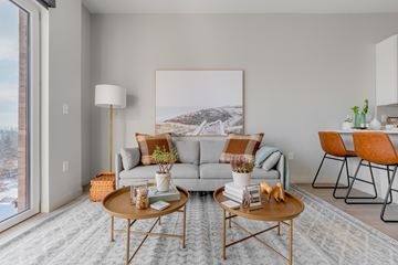 Cleveland apartment for rent - A living room with a grey couch, a coffee table, and a large painting on the wall.
