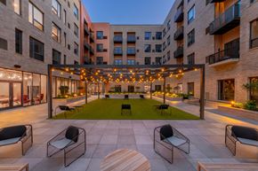 Cleveland apartment for rent - A patio with chairs and a table is surrounded by apartment buildings.