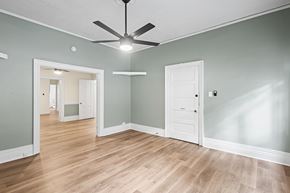 Denver apartment for rent - A room with a ceiling fan and wooden floors.