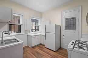 Denver apartment for rent - A kitchen with white appliances and wooden floors.