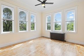 Denver apartment for rent - A room with a ceiling fan and a radiator on the wall.
