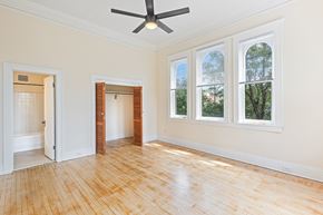 Denver apartment for rent - A room with a ceiling fan and three windows.