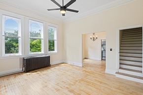 Denver apartment for rent - A room with a ceiling fan and a window with a view of trees.