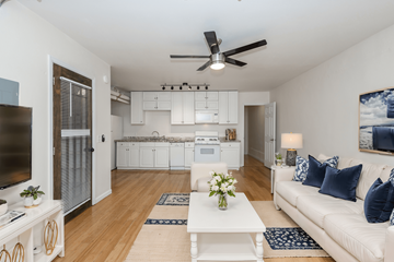Denver apartment for rent - A living room with a white couch and a ceiling fan.
