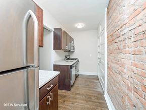 Chicago apartment for rent - a renovated kitchen with a brick wall and stainless steel appliances