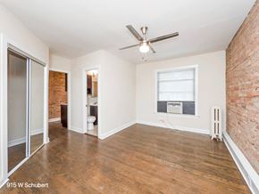 Chicago apartment for rent - an empty living room with a ceiling fan and a window