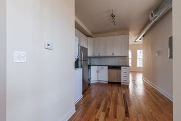 Chicago apartment for rent - A kitchen with white cabinets and a wooden floor.