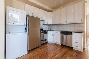 Chicago apartment for rent - A kitchen with a white fridge and wooden floors.