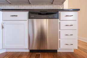 Chicago apartment for rent - A stainless steel dishwasher is in a kitchen with white cabinets.