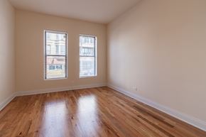 Chicago apartment for rent - A room with wooden floors and two windows.