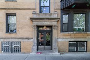 Chicago apartment for rent - A brown building with a black door and windows.