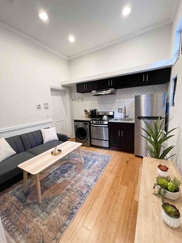 Chicago apartment for rent - A modern kitchen with a grey sofa and wooden table.