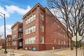 Chicago apartment for rent - A red brick building with a fire escape on the left side.