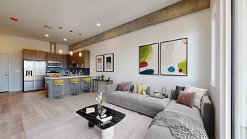 Denver apartment for rent - a living room with a couch and a table in front of a kitchen