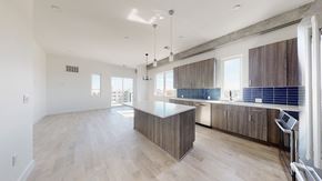 Denver apartment for rent - A spacious kitchen with wooden cabinets and a large island.