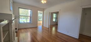 Chicago apartment for rent - A large empty room with wooden floors and white walls.