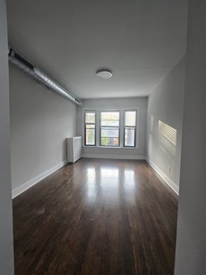 Chicago apartment for rent - A room with wooden floors and a window.