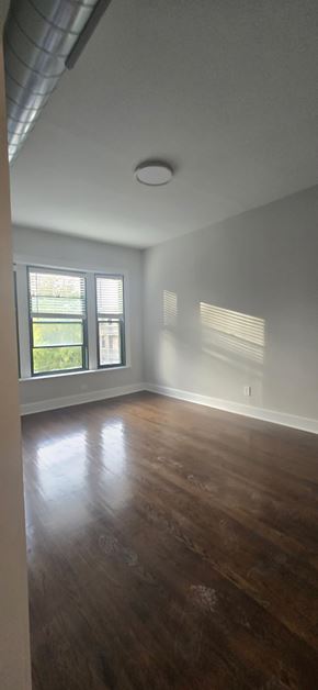 Chicago apartment for rent - A room with wooden floors and a window letting in light.