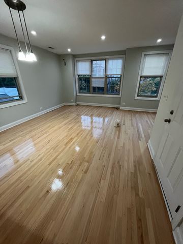 Chicago apartment for rent - an empty living room with wooden floors and windows
