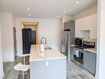 Chicago apartment for rent - A kitchen with a white counter and a black fridge.