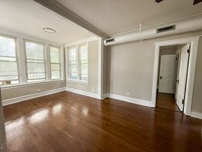 Chicago apartment for rent - A room with wood floors and white walls.