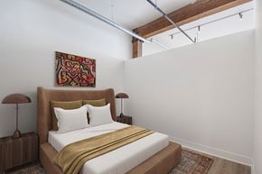 Chicago apartment for rent - A bedroom with a bed, two lamps, and a painting on the wall.