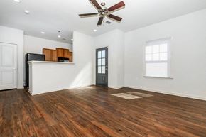 Oxford apartment for rent - an empty living room with a ceiling fan and a kitchen