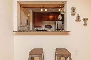 Baton Rouge apartment for rent - A kitchen with a counter and two stools. at The Cove at State Street Apartments, Baton Rouge