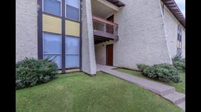 Shreveport apartment for rent - A building with a balcony and a small garden in front.