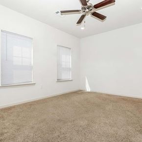 Oxford apartment for rent - a white carpeted bedroom with a fan