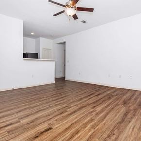 Pontotoc apartment for rent - an empty living room with a ceiling fan and a kitchen