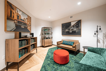 Baton Rouge apartment for rent - A living room with a green couch and a red ottoman.