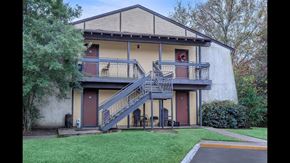 Shreveport apartment for rent - A two-story house with a red door and a balcony.