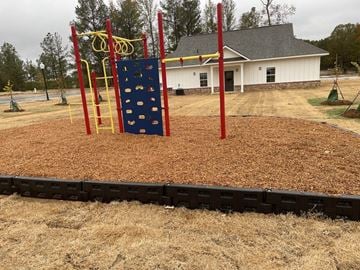 Tupelo apartment for rent - a playground with a blue rock climbing wall in front of a house