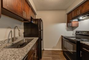 Baton Rouge townhouse for rent - A kitchen with a black refrigerator and a black oven.