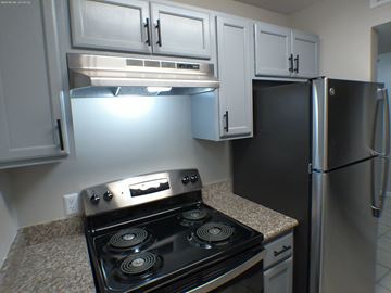 Baton Rouge apartment for rent - A kitchen with a black stove top oven and a black refrigerator.