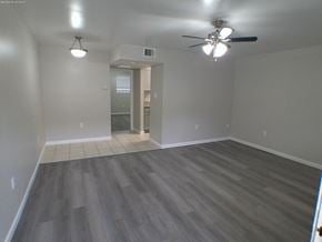 Baton Rouge apartment for rent - an empty living room with wooden floors and a ceiling fan