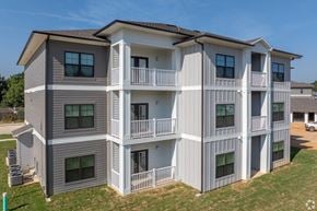 Shreveport apartment for rent - A large two-story apartment building with balconies and multiple windows.